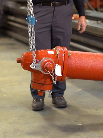 Hydrant setter lifting a hydrant up in warehouse